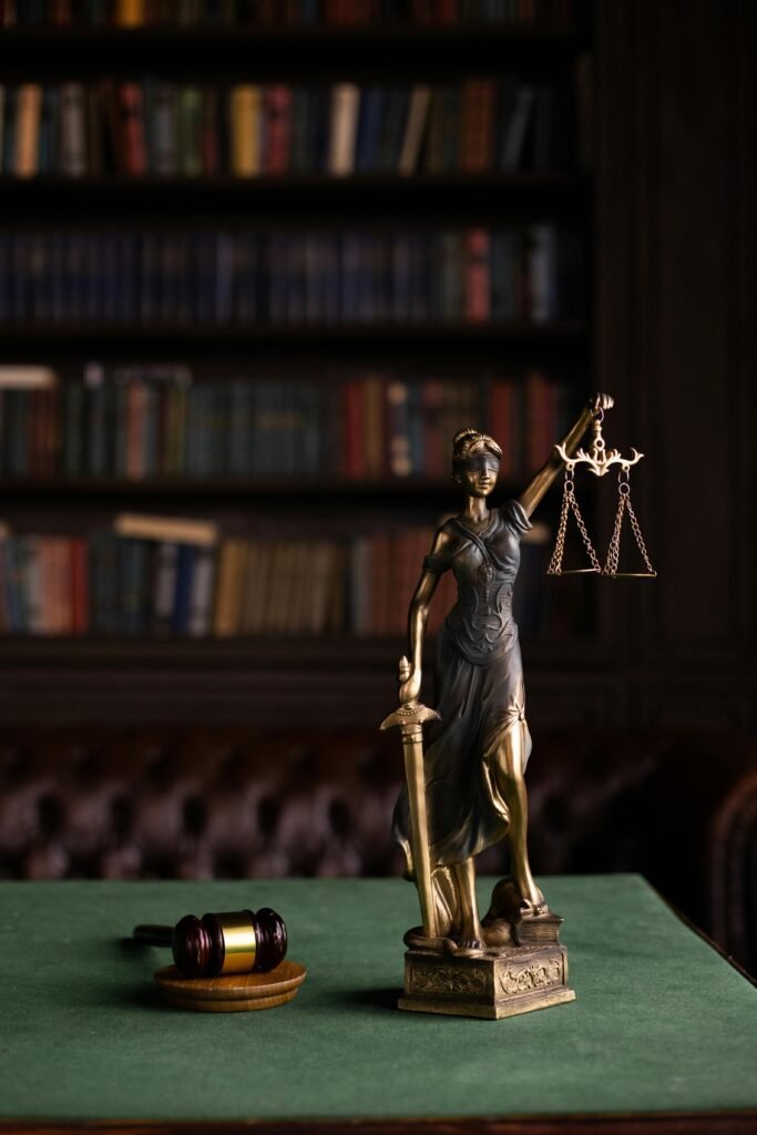 pexels-photo-6077123-6077123 Lady Justice and gavel on a table in a classic law library setting.